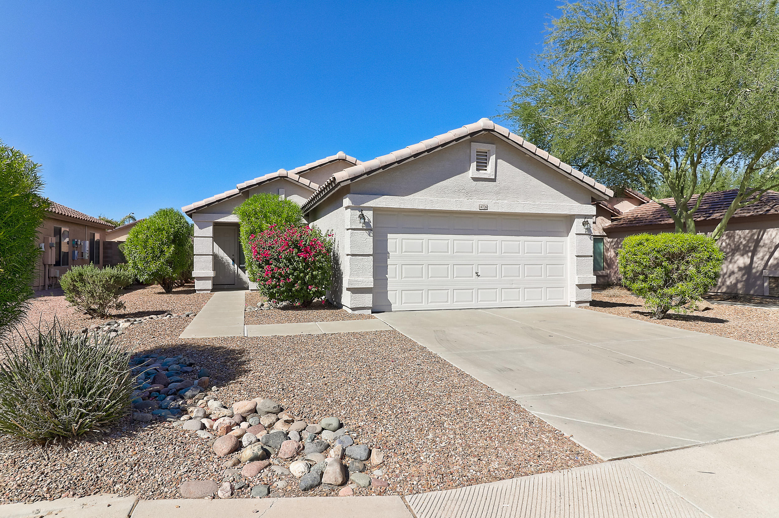 14726 West Calavar Road Surprise, AZ 85379 - Photo 3 of 24 a view of a house with a yard and garage