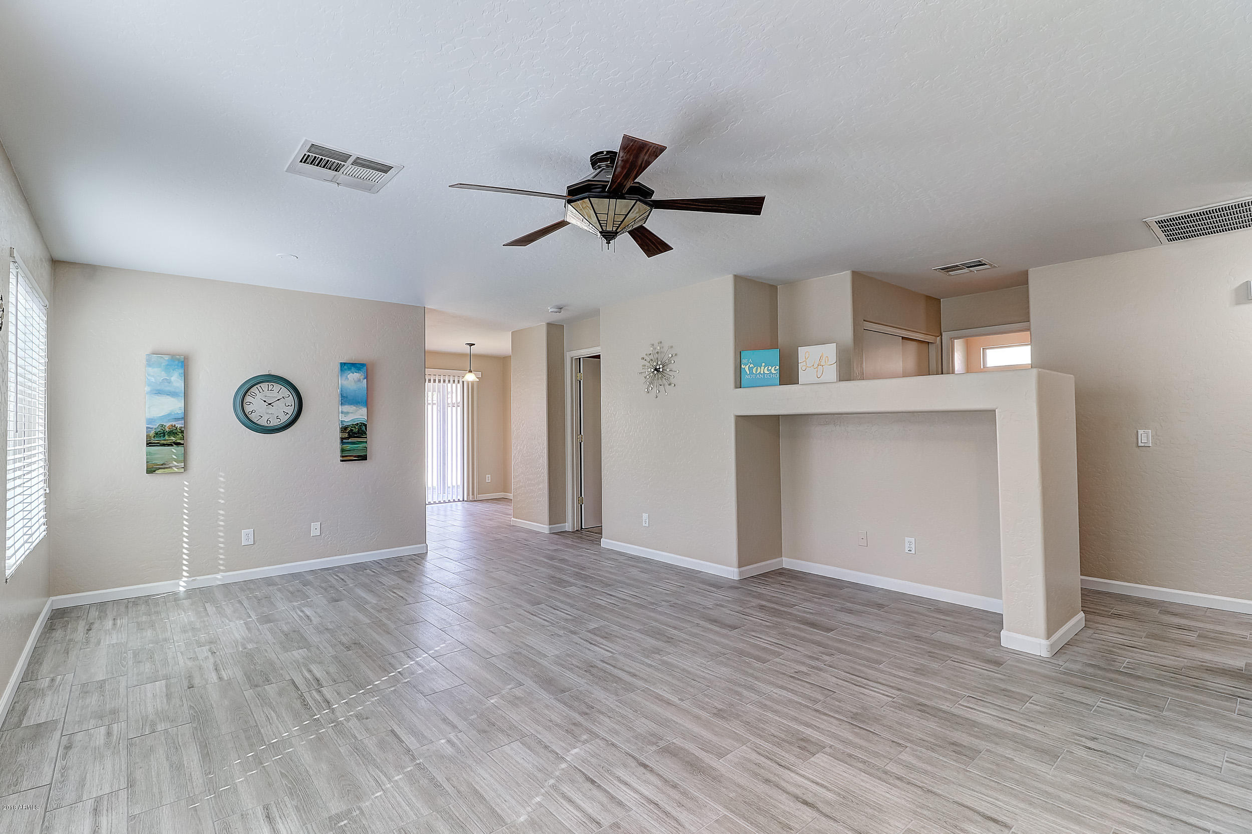 14726 West Calavar Road Surprise, AZ 85379 - Photo 4 of 24 a view of a kitchen with wooden floor and a ceiling fan