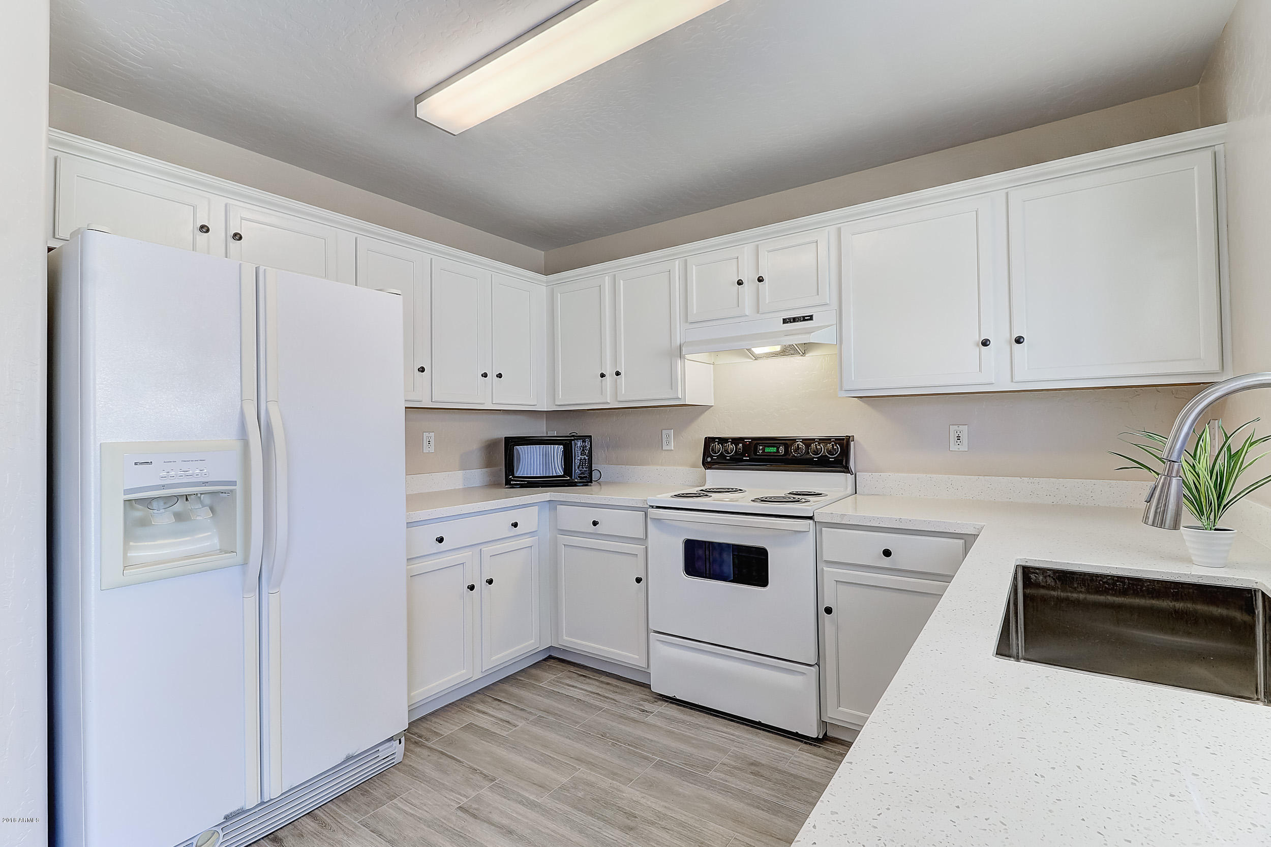 14726 West Calavar Road Surprise, AZ 85379 - Photo 8 of 24 a white refrigerator freezer sitting inside of a kitchen
