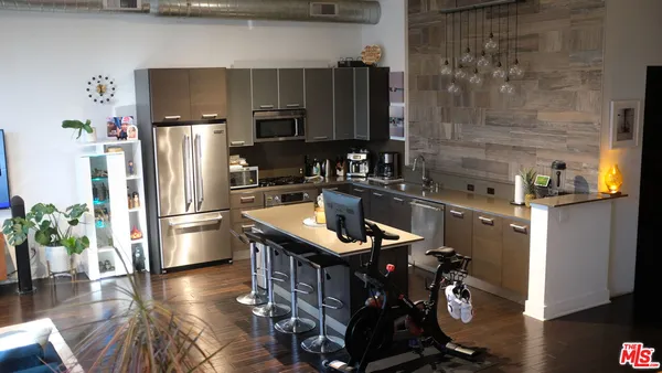 a kitchen with stainless steel appliances granite countertop a refrigerator a stove and a wooden floors