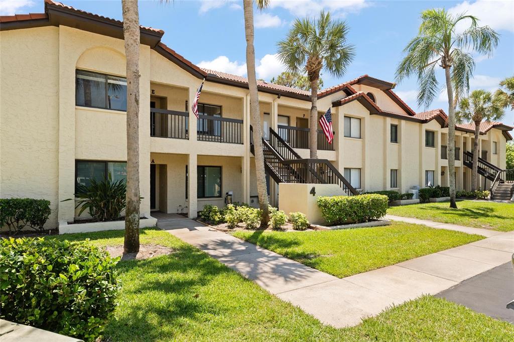 1801 East Lake Road South, Unit 4E Palm Harbor, FL 34685 - Photo 1 of 26 a front view of a house with yard and green space