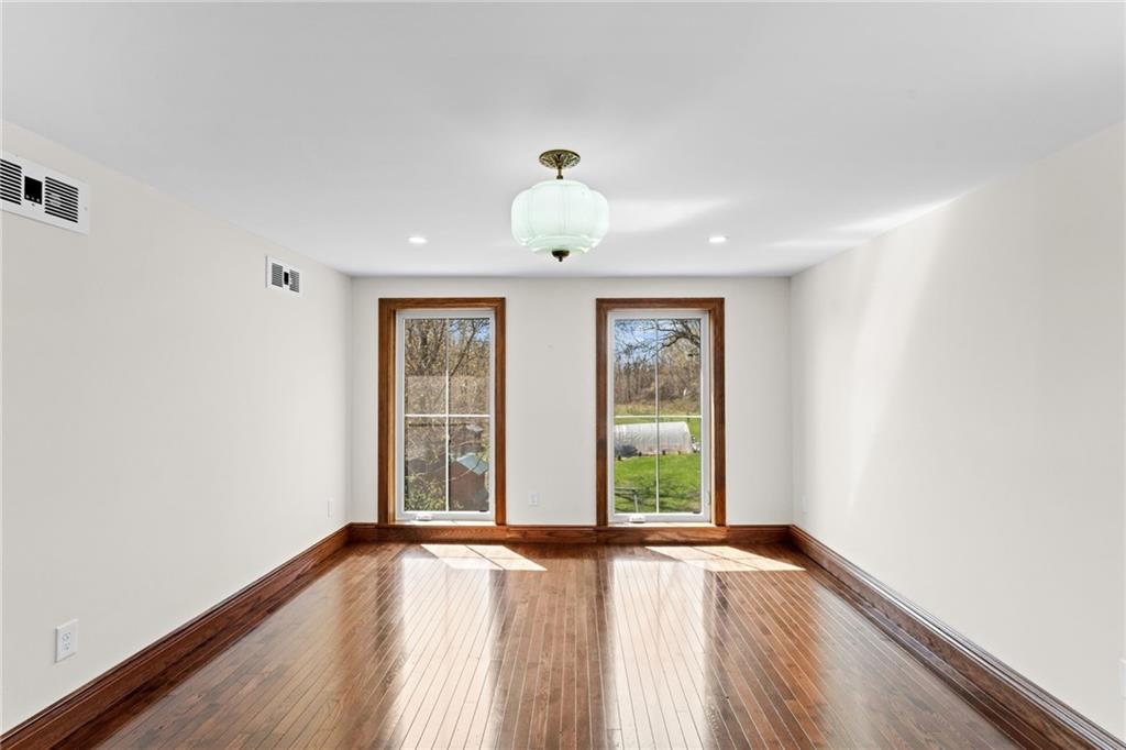 351 Engle Road Industry, PA 15052 - Photo 19 of 50 an empty room with wooden floor chandelier and windows