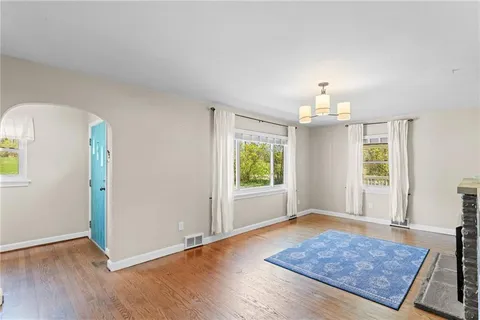 an empty room with wooden floor and window