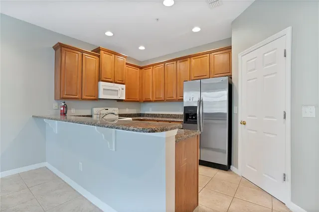 a kitchen with stainless steel appliances granite countertop a refrigerator sink and cabinets