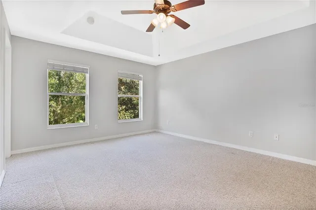 an empty room with windows and fan