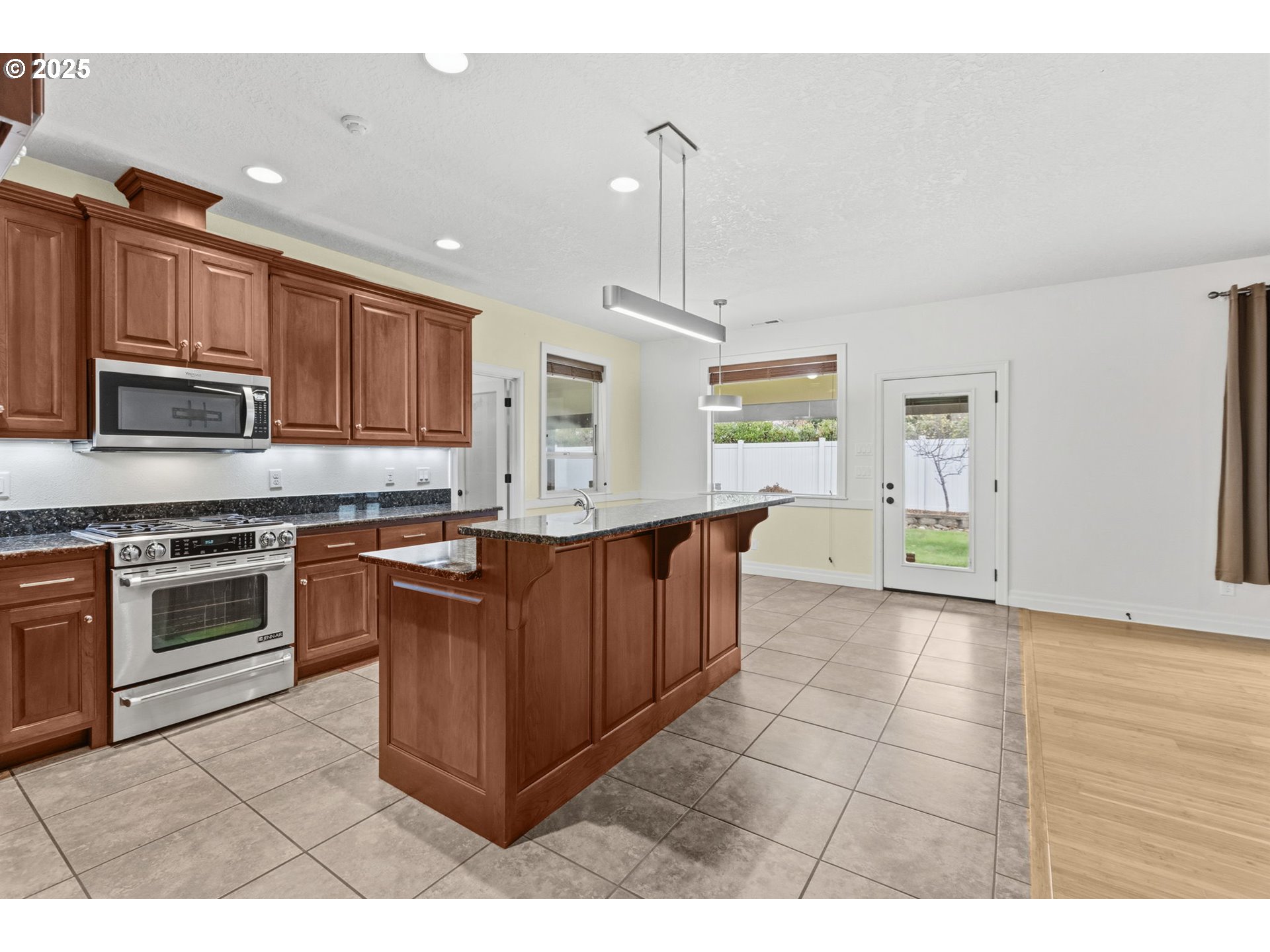 4879 Northeast Granite Avenue Albany, OR 97321 - Photo 23 of 47 a kitchen with stainless steel appliances granite countertop a stove a sink and a microwave