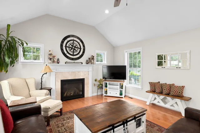 a living room with furniture a fireplace and a flat screen tv