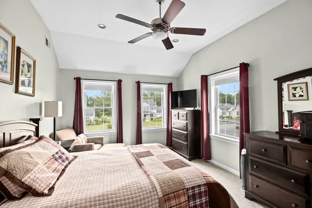 a bedroom with a bed dresser and a large window