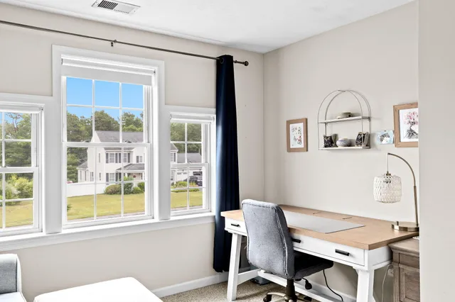 a view of a workspace with furniture and a window