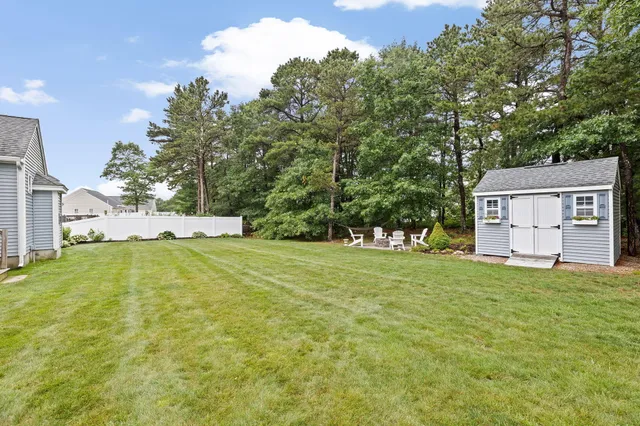 a view of a house with a yard garage and tree