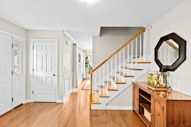 a view of an entryway with wooden floor and staircase