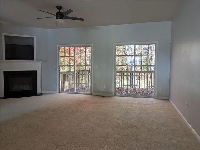 a view of an empty room with a fireplace and a window