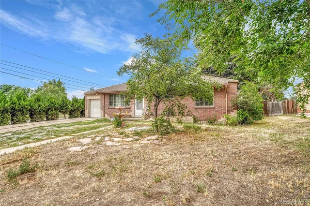 a view of a house with backyard and tree