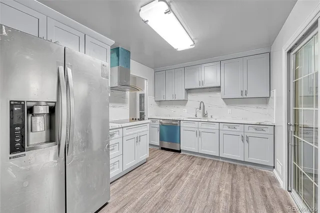 a kitchen with granite countertop a refrigerator sink and cabinets