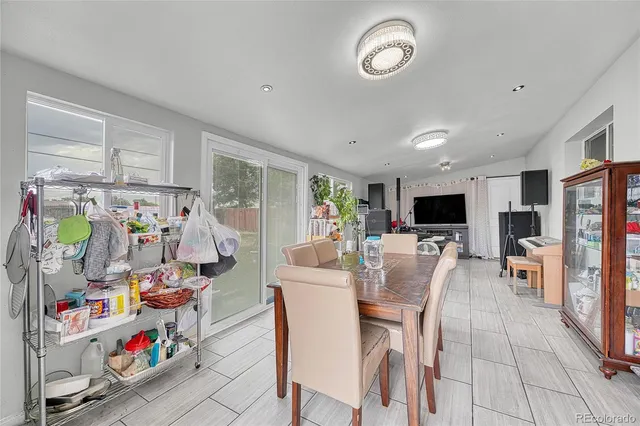 a dining room with furniture and a flat screen tv