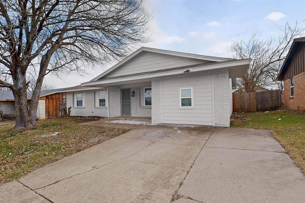 a view of a yard in front of a house with large tree