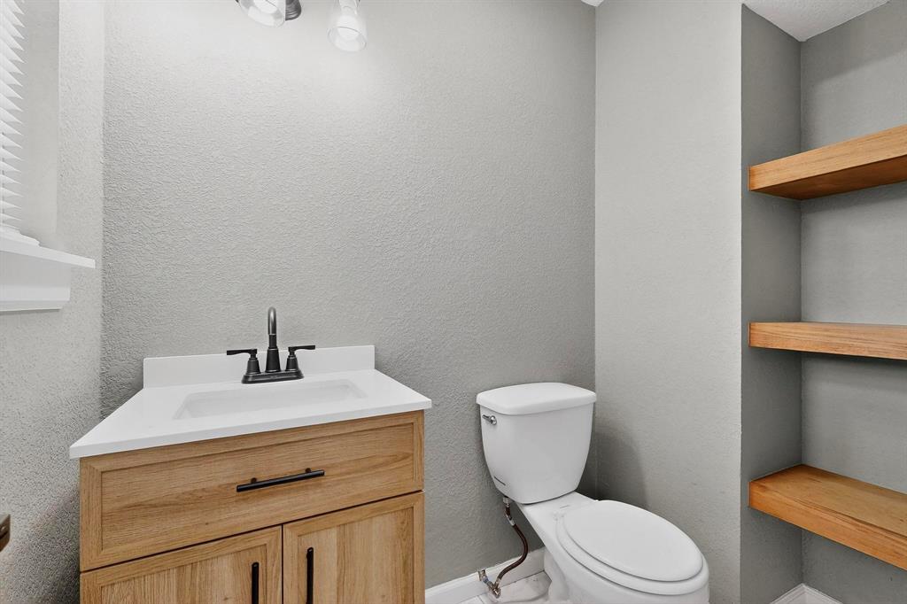 3442 Tioga Street Dallas, TX 75241 - Photo 12 of 28 a bathroom with a toilet sink and mirror