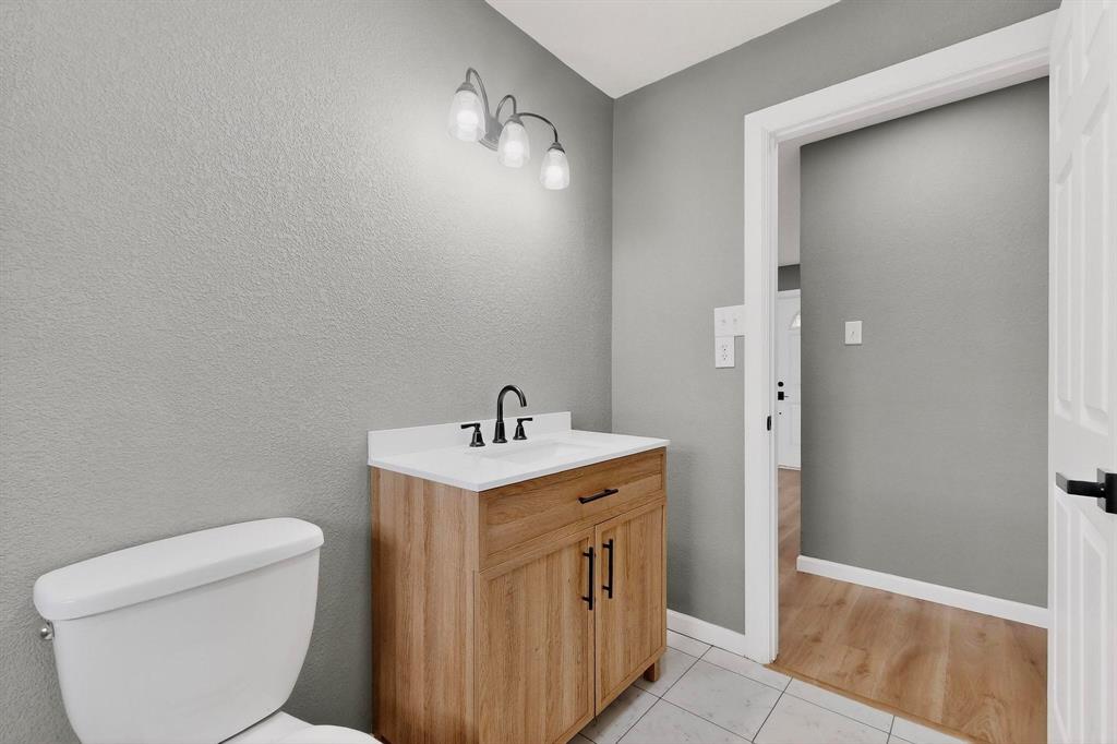 3442 Tioga Street Dallas, TX 75241 - Photo 15 of 28 a bathroom with a toilet a sink a vanity and mirror