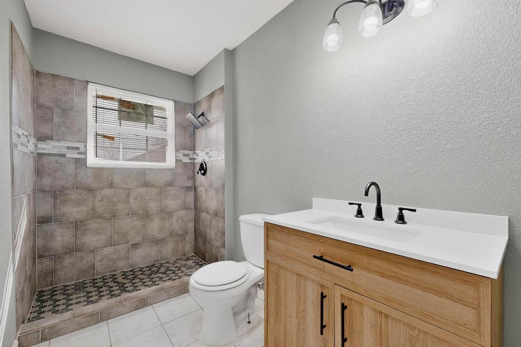 3442 Tioga Street Dallas, TX 75241 - Photo 16 of 28 a bathroom with a sink a toilet and shower