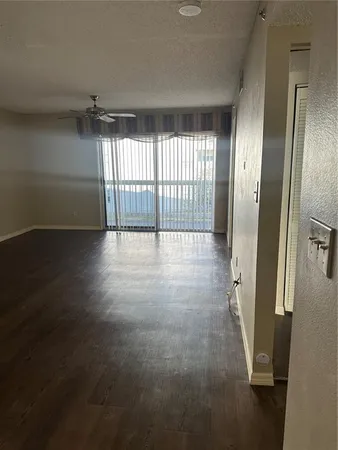 a view of a room with wooden floor chandelier and fireplace