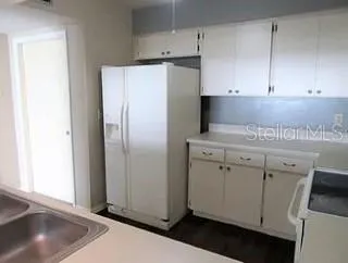 a kitchen with a refrigerator sink and cabinets