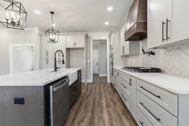a large kitchen with stainless steel appliances granite countertop a lot of counter space and wooden floors