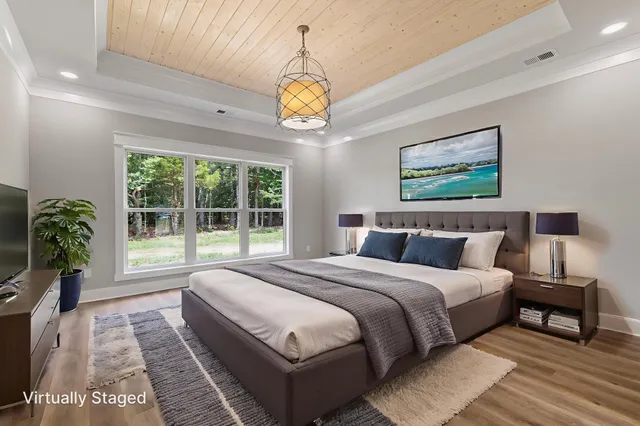 a spacious bedroom with a large bed and a chandelier