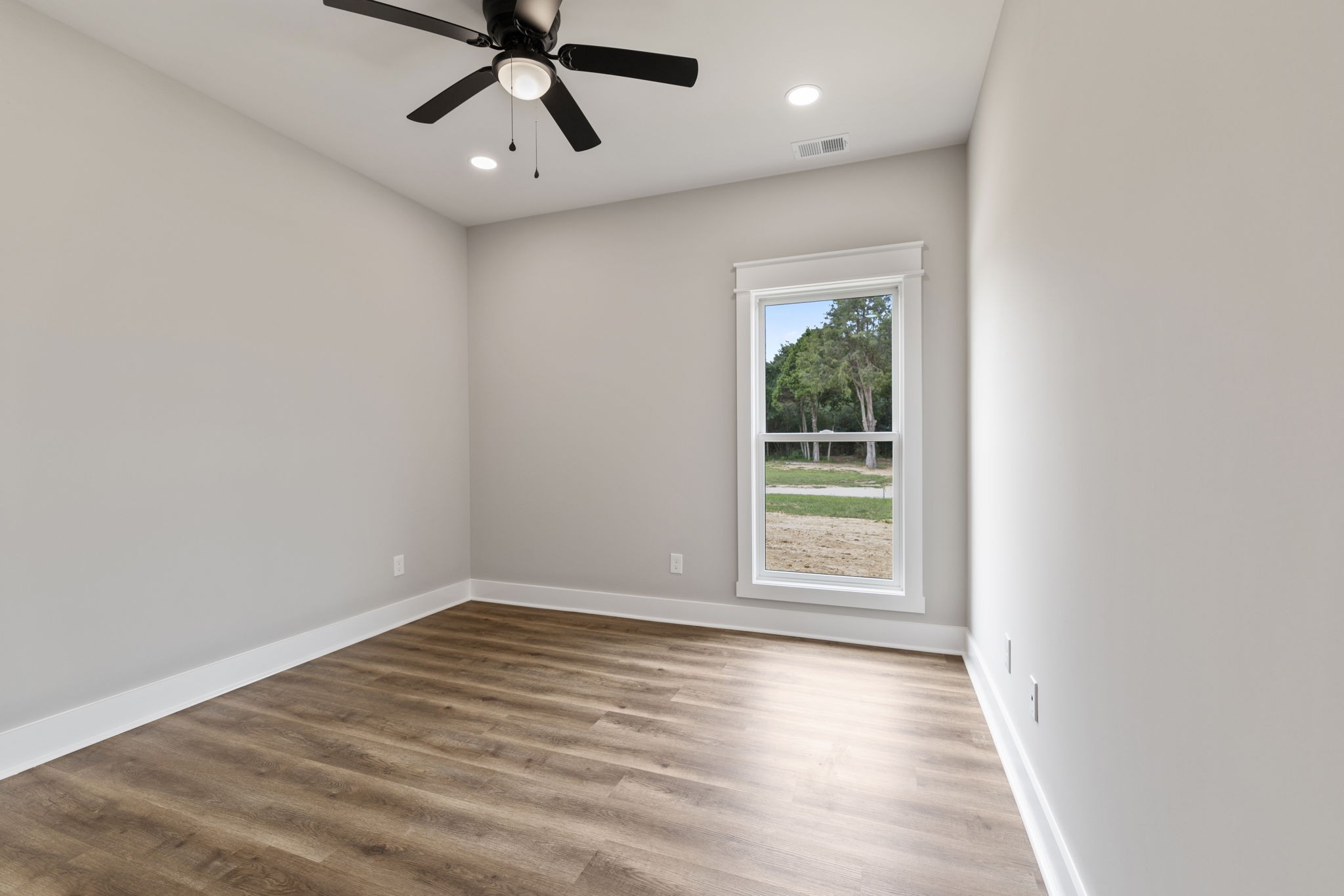 887 Ovoca Lake Road Tullahoma, TN 37388 - Photo 40 of 58 en empty room with wooden floor fan and windows