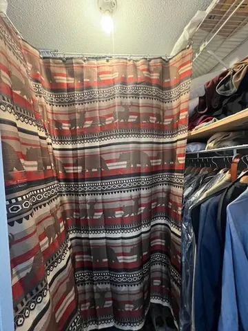 a bedroom with bed couch and window