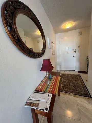 a living room with furniture a rug and a floor to ceiling window