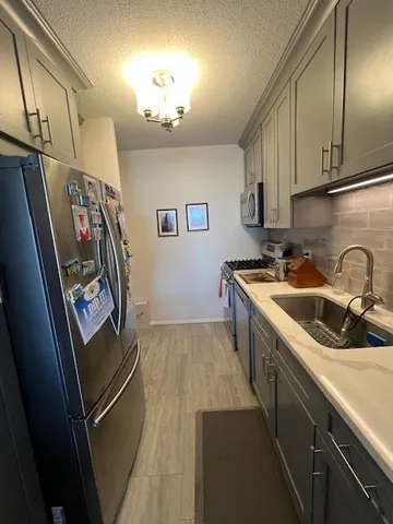 a kitchen with stainless steel appliances granite countertop a sink refrigerator and cabinets