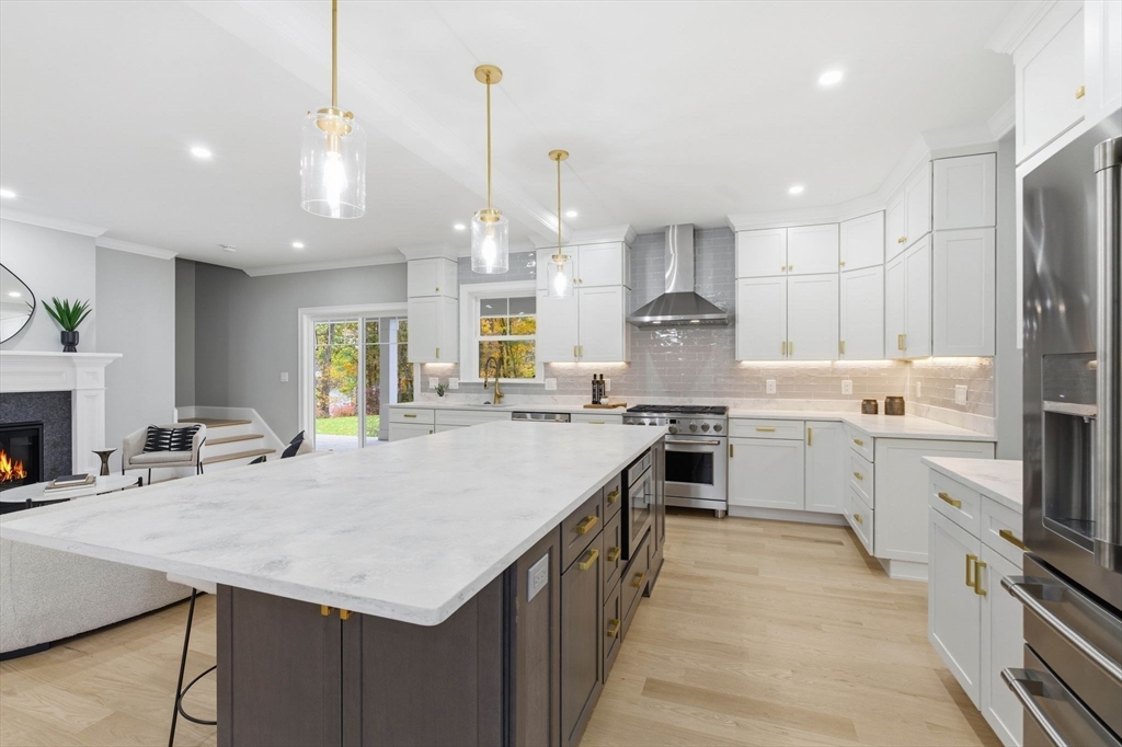 4 Chatham Lane Danvers, MA 01923 - Photo 10 of 40 a kitchen with a stove a sink a kitchen island with wooden cabinets and chairs