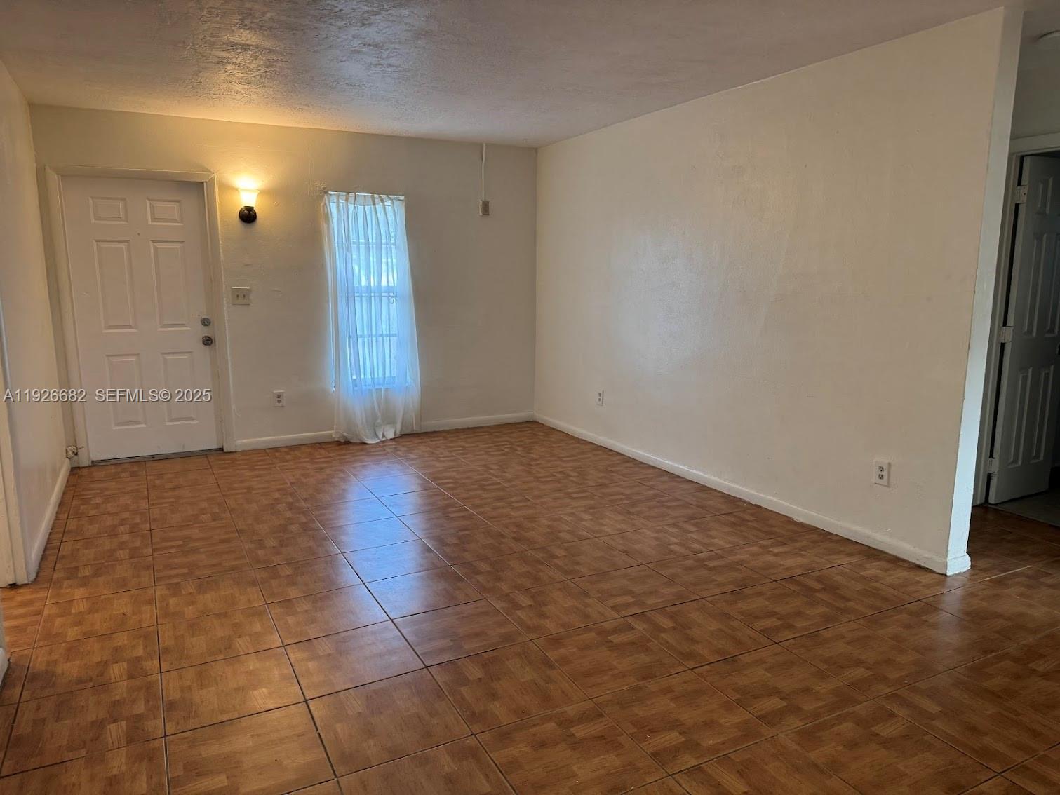 19354 Northwest 28th Court, Unit 19354 Miami Gardens, FL 33056 - Photo 5 of 17 an empty room with wooden floor and windows