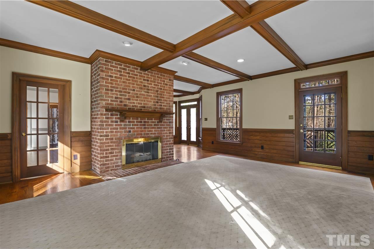 8528 Bournemouth Drive Raleigh, NC 27615 - Photo 8 of 30 Coffered ceilings rise above this beautiful family room with a crackling fireplace. The side entry / covered porch enters into this room.