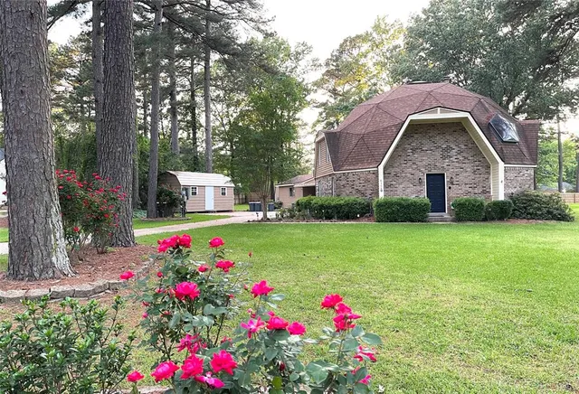 a view of a house with a big yard and large tree