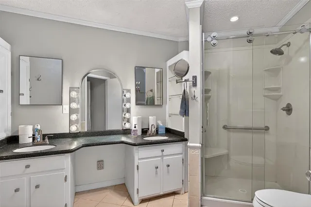 a bathroom with a double vanity sink mirror and shower