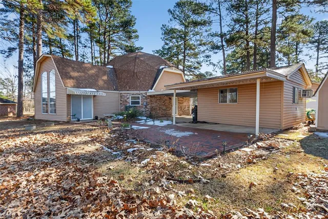 a view of a house with a yard and large tree