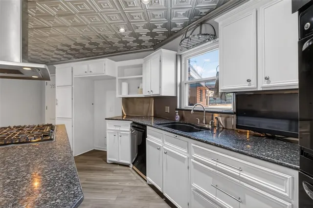 a kitchen with stainless steel appliances a stove a sink and a microwave