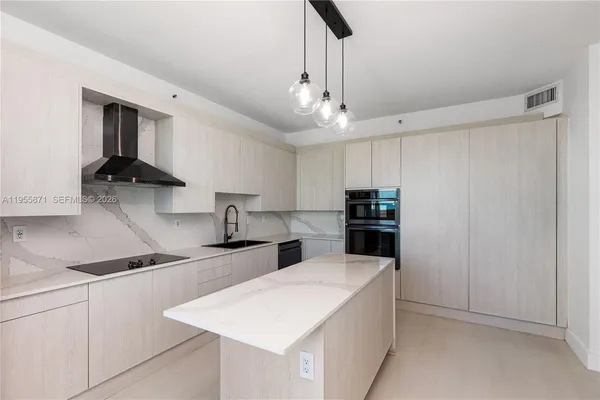 a kitchen with stainless steel appliances a sink a stove and a refrigerator