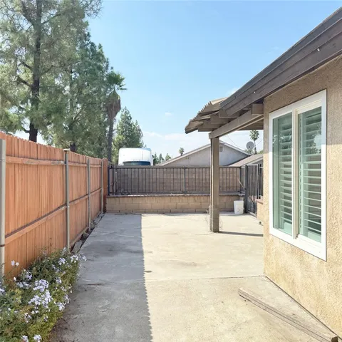 a view of backyard with wooden fence and large trees