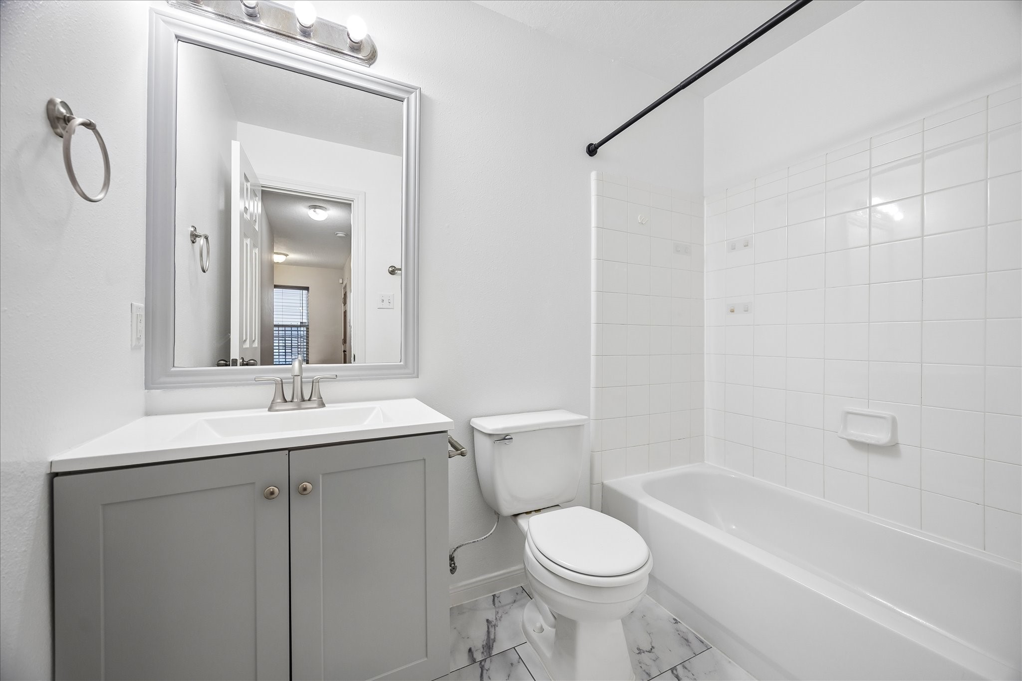 1510 Robin Street, Unit A Houston, TX 77019 - Photo 13 of 17 a bathroom with a toilet a sink a mirror a bathtub and vanity