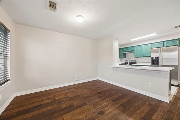 a view of a kitchen with a sink and dishwasher with wooden floor
