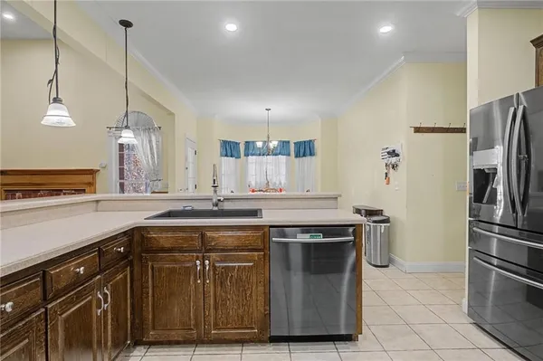 a kitchen with stainless steel appliances granite countertop a sink a stove a refrigerator and island