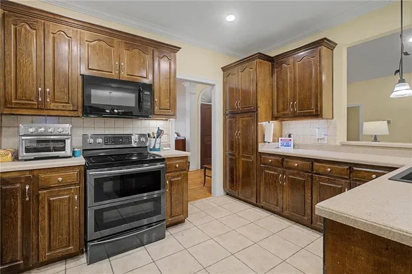 a kitchen with stainless steel appliances granite countertop a stove microwave refrigerator and sink