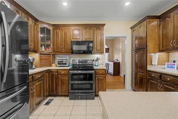a kitchen with stainless steel appliances a stove sink refrigerator and cabinets