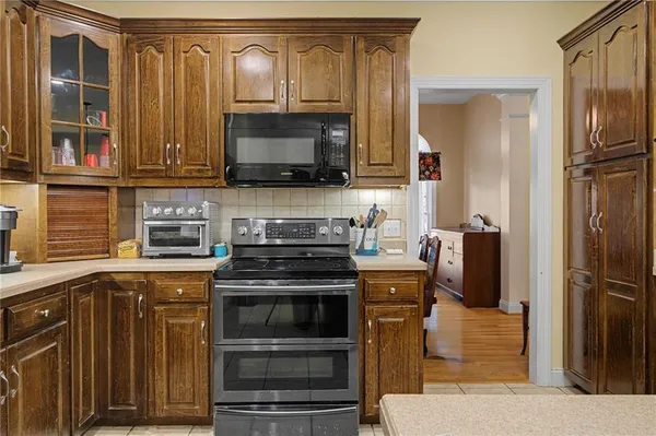 a kitchen with stainless steel appliances wooden cabinets and a stove top oven