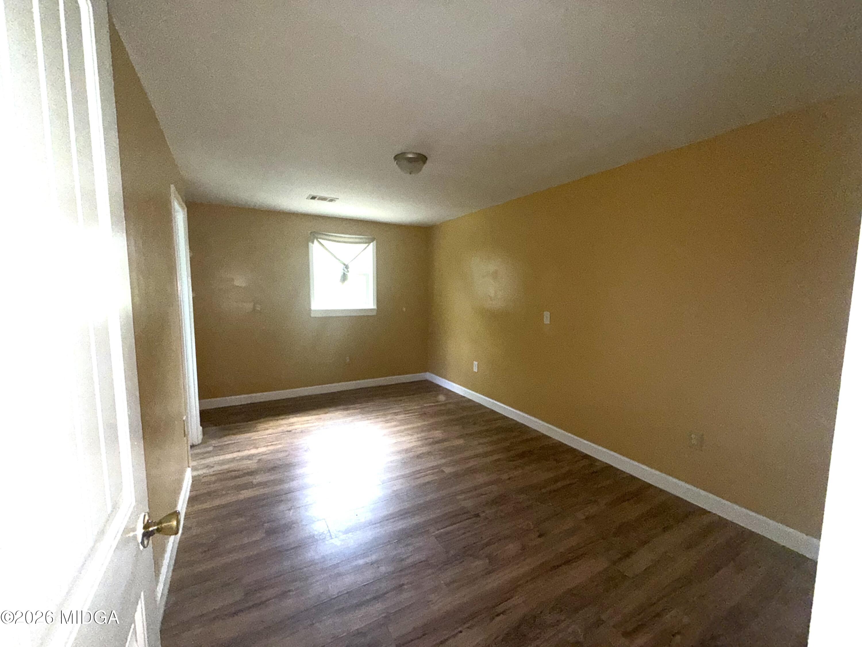 615 Paul Street Macon, GA 31206 - Photo 8 of 24 an empty room with wooden floor and windows