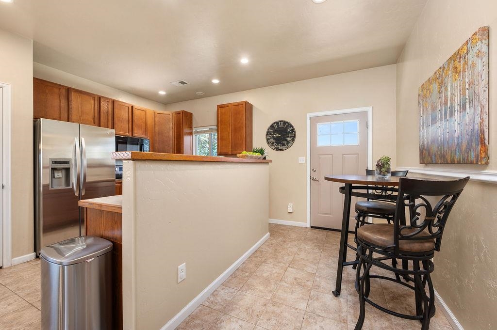 2436 1/2 Jack Creek Road Grand Junction, CO 81505 - Photo 14 of 36 a kitchen with stainless steel appliances a refrigerator a stove a sink a dining table and chairs with wooden floor