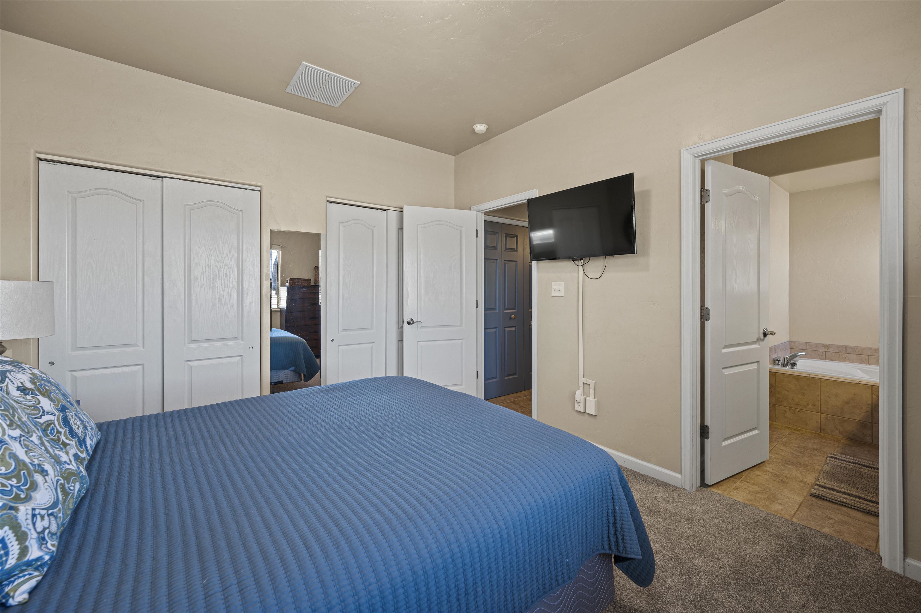 2436 1/2 Jack Creek Road Grand Junction, CO 81505 - Photo 16 of 36 a bedroom with a bed and a flat screen tv