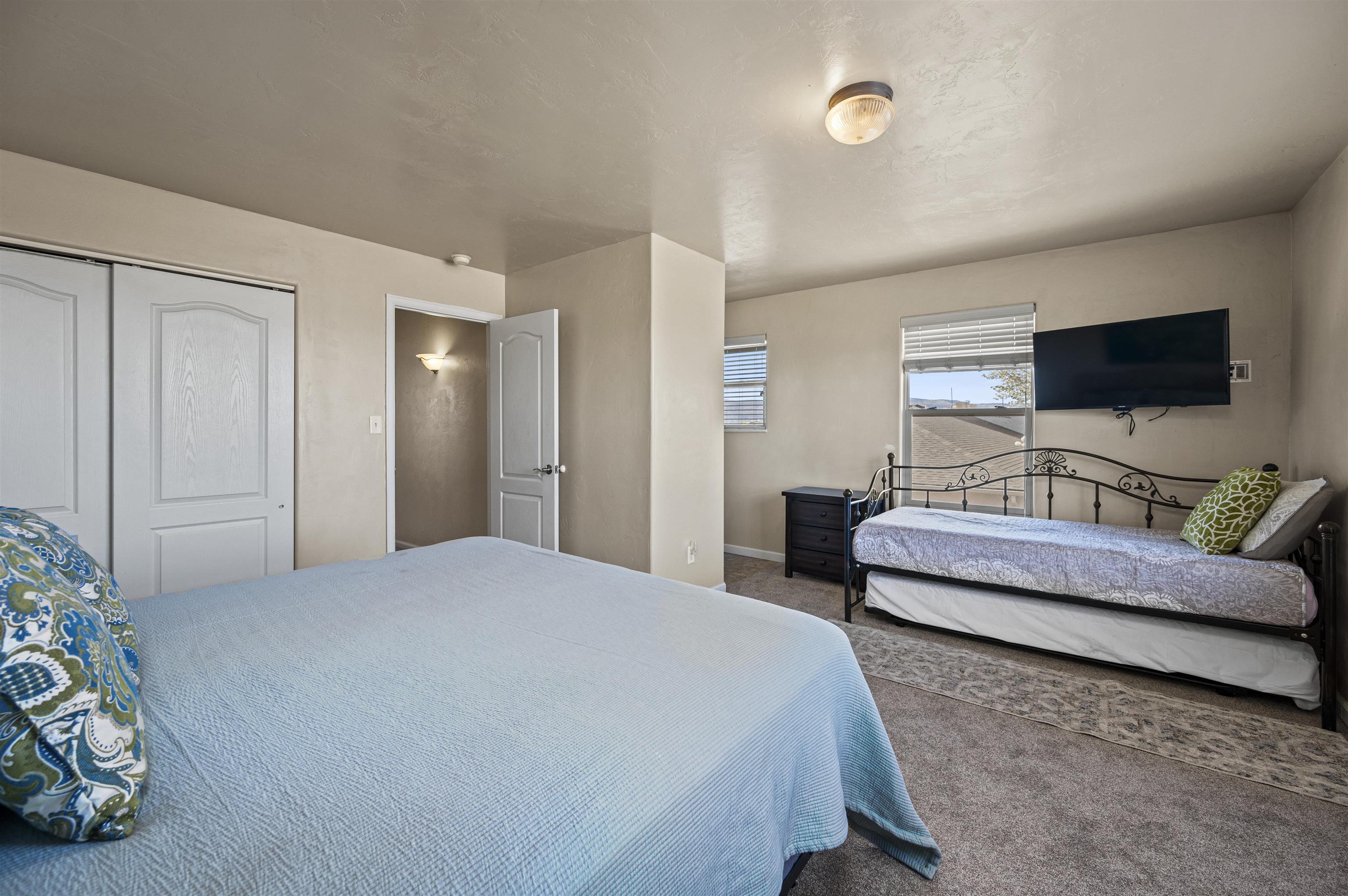 2436 1/2 Jack Creek Road Grand Junction, CO 81505 - Photo 19 of 36 a bedroom with bed and a flat screen tv